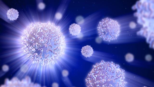 3D rendering of glowing T cells with light rays on a dark blue background, highlighting their detailed surface structure 